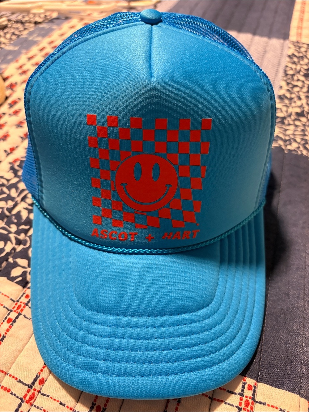 Ascot + Hart Blue Trucker Hat with Orange Smiley Checker Graphic